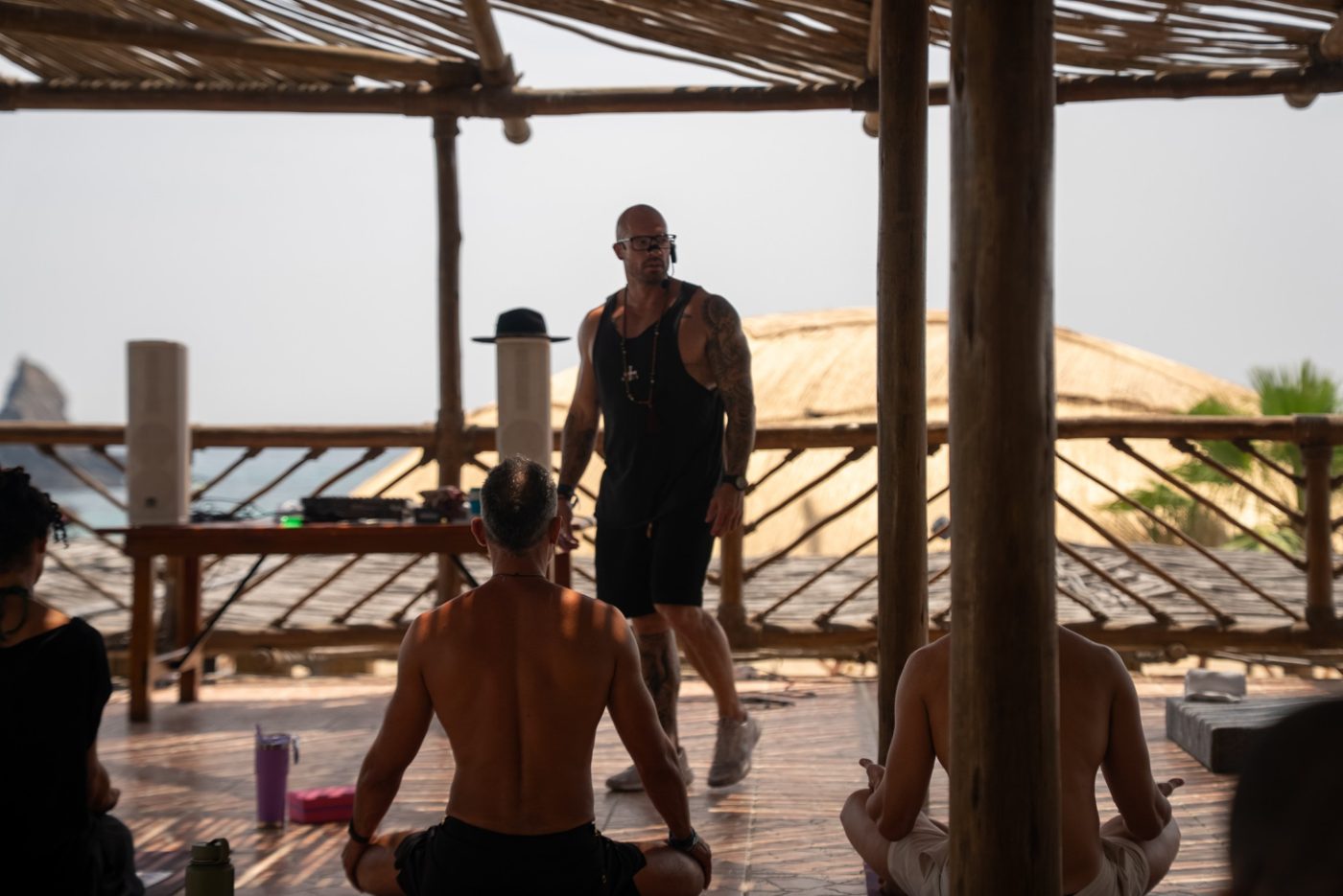 Ashley leading a breathwork session on an open-air deck by the sea
